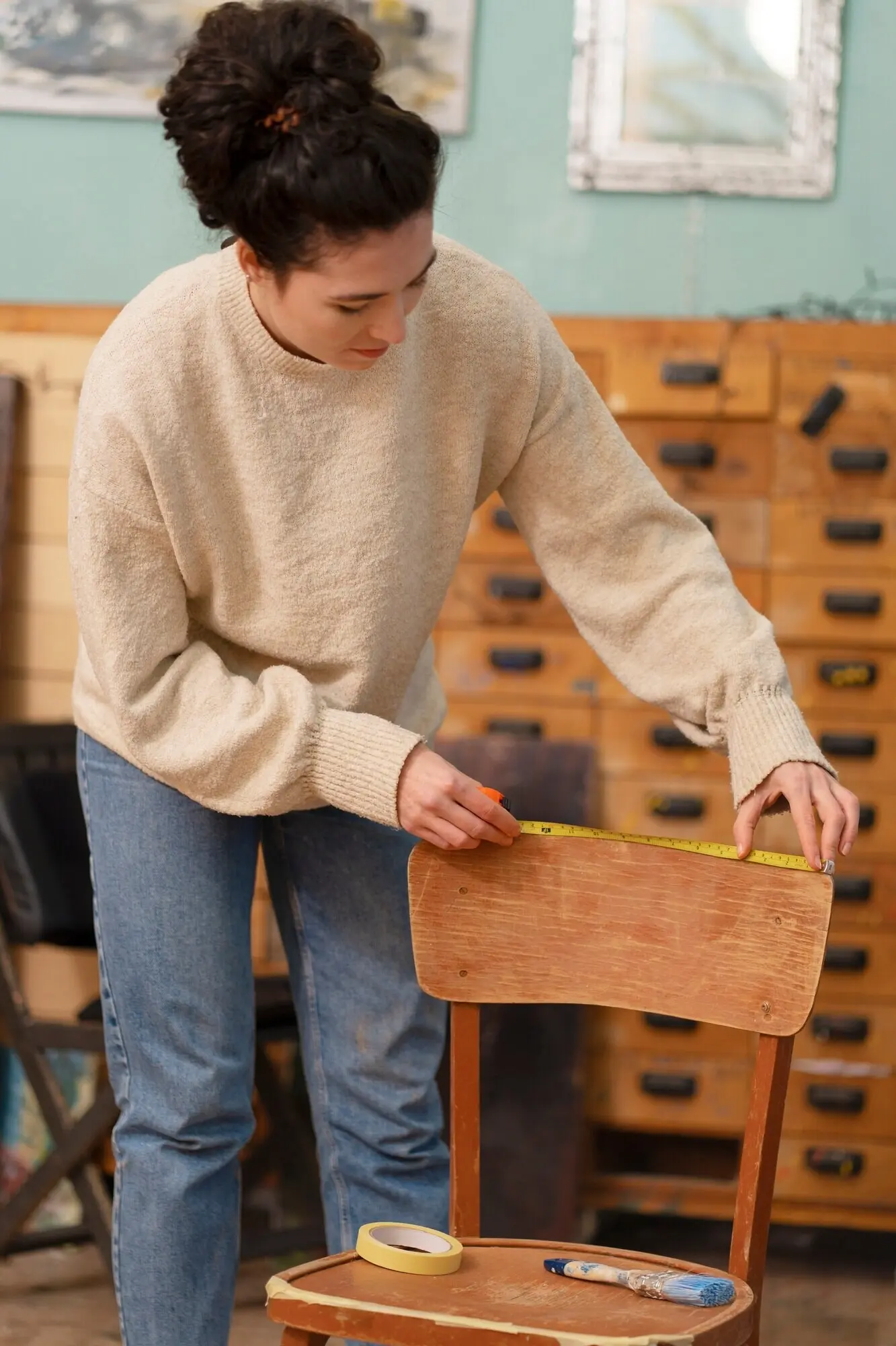 Frau restauriert einen Holzstuhl, Vorderansicht